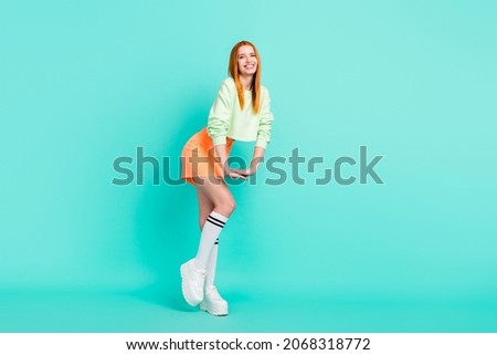 Photo of shiny sweet young woman wear green shirt dancing smiling isolated teal color background