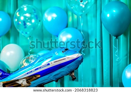 bright blue balloons and balloon plane on a blue background. festive decorations concept. selective focus