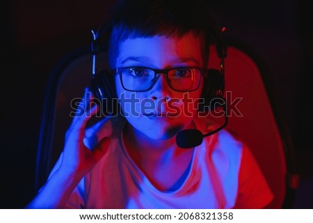 Boy in the headphones is playing a game.