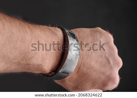 Broken wrist watch on mans wrist ,representing lost time concept. Royalty-Free Stock Photo #2068324622