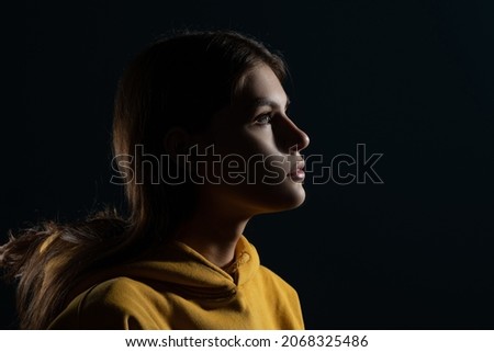 Confident look ahead, concept. A young Caucasian woman, side view of the illuminated silhouette of the head, looks to the right. The mysteries of the subconscious, the brain and the mind