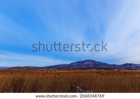 Mount Sister in the city of Nakhodka during a bright dawn. A low hill in front of a high mountain in the Primorsky Territory.
