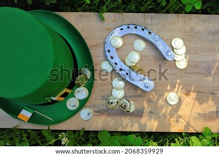 St.Patrick 's Day.Green leprechaun hat,flag of Ireland,gold decorative coins, metal horseshoe in green clover.Irish traditional spring holiday.Saint Patrick background