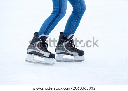 feet on the skates of a person rolling on the ice rink
