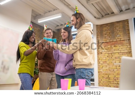 Young people celebrating in the office and looking happy and enjoyed
