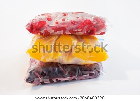 Three packages with frozen fruts on white background, front view. Royalty-Free Stock Photo #2068400390