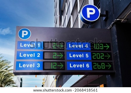 Spaces available outdoor parking sign with counter indicating the number of open or empty parking spaces at garage levels at multi level parking lot entrance