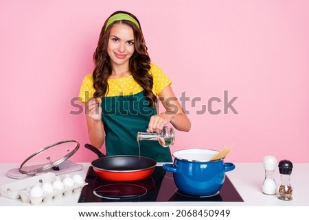 Photo of adorable pretty young woman wear green apron frying tasty breakfast smiling isolated pink color background Royalty-Free Stock Photo #2068450949