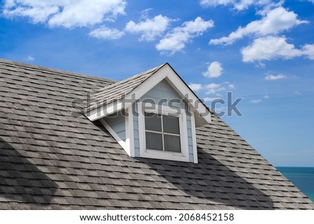 grey roof shingle with with garret house. house roof near sea in morning time. Royalty-Free Stock Photo #2068452158