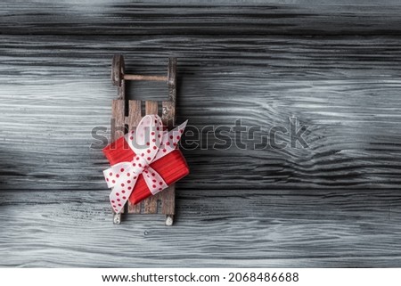 Santa’s sleigh with red box on rustic wooden background with copy space