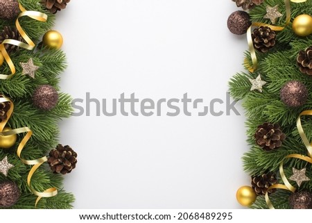 Top view photo of gold and glowing brown christmas tree balls pine cones small stars and serpentine on pine branches on isolated white background with copyspace