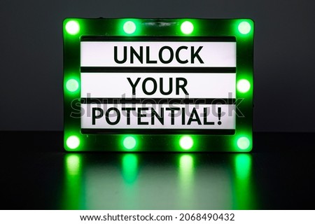 Lightbox with green lights in dark room with words - unlock your potential!