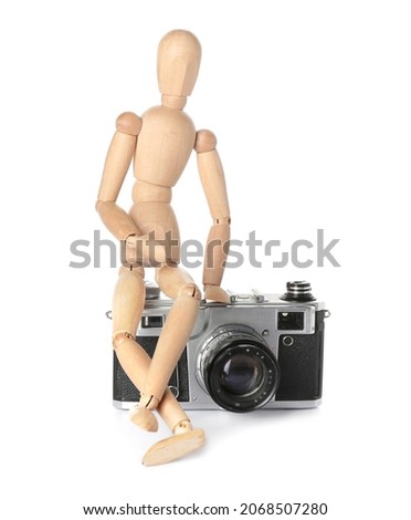 Wooden mannequin with photo camera on white background