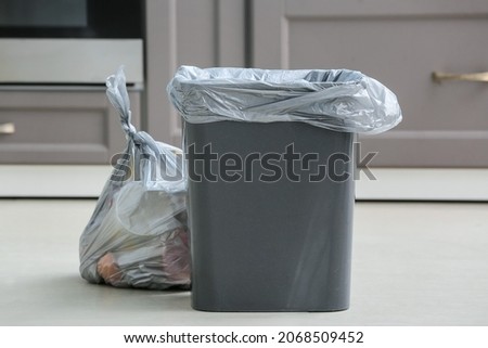 Bag with garbage and rubbish bin in kitchen Royalty-Free Stock Photo #2068509452