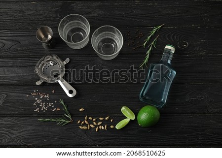 Frame made of glasses and ingredients for gin tonic on dark background