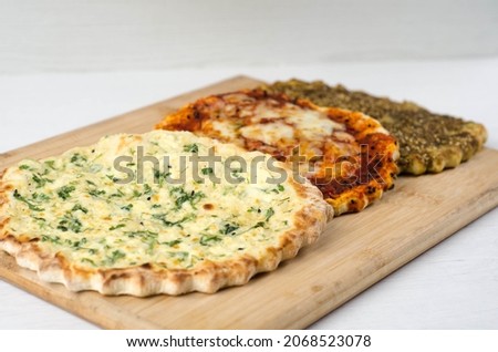 Zaatar manakeesh with olives, olive oil, cheese and sauce on a wooden board