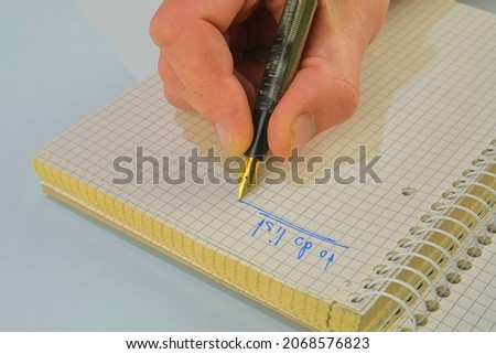 Man hand writing text - to do list - in notebook. Fountain pen, spiral notebook on table. Business, planning, education concept. Top view. Flat lay. Copy space