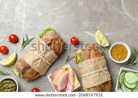 Concept of tasty eating with ciabatta sandwiches on gray textured table