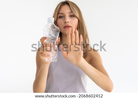 Young beautiful woman recycling plastic bottles standing over isolated white background with open hand doing stop sign with serious and confident expression, defense gesture