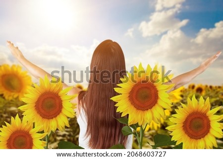 Sunny beautiful picture of young cheerful girl holding hands up and looking at sunrise