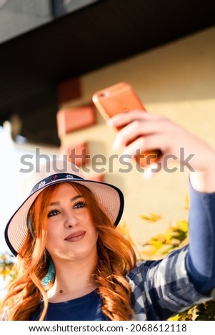 young orange hair girl take self-photo in park