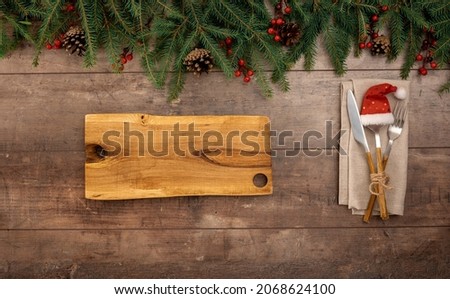 Christmas table setting in retro style with blank wooden board for text. Christmas table setting in retro style. Christmas decorations and Cutlery on wooden rustic table. Top view, copy space
