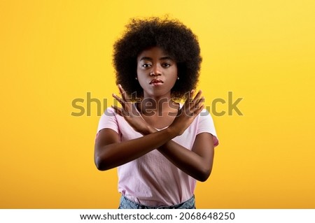 Refusal concept. Upset black lady showing stop gesture with crossed hands, refusing something unwanted while standing over yellow studio background Royalty-Free Stock Photo #2068648250