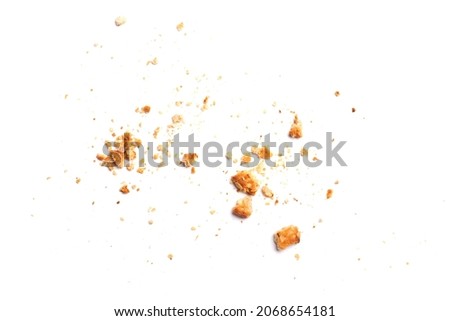 Scattered crumbs of vanilla chip butter cookies isolated on white background. Close-up view of brown crackers. Macro shot of yellow biscuit cake leftovers for your design Royalty-Free Stock Photo #2068654181