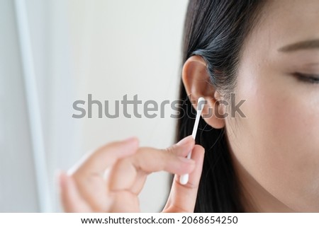 woman cleaning ear with cotton swab. Healthcare and ear cleaning concept Royalty-Free Stock Photo #2068654250