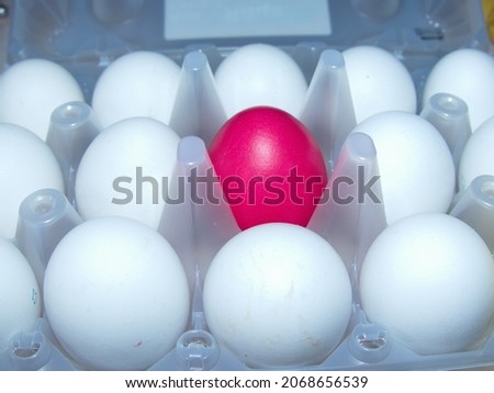 All white and one red upstart. Red surrounded by white. Colorful Easter eggs are part of the Easter meal. Easter (Bright Sunday of Christ) is the oldest and most important Christian holiday.