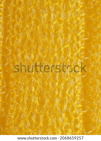 close up, background, texture, large vertical banner. heterogeneous surface structure bright saturated yellow sponge for washing dishes, kitchen, bath. full depth of field. high resolution photo