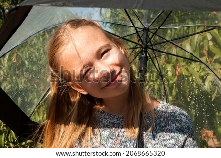 Teenager girl with a transparent umbrella after the rain. 
