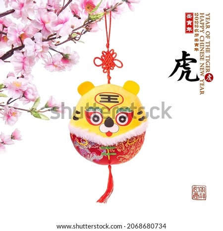 Traditional Chinese cloth doll tiger,2022 is year of the tiger,Chinese characters mean: "tiger".Rightside chinese wording and seal mean:Chinese calendar for the year.underside seal mean: good bless. Royalty-Free Stock Photo #2068680734