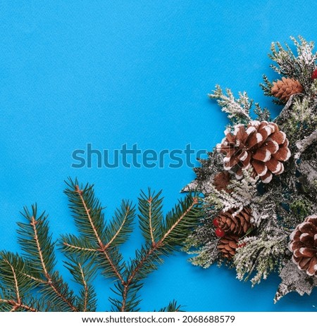 Blue Christmas background with pine cones and Christmas tree branches