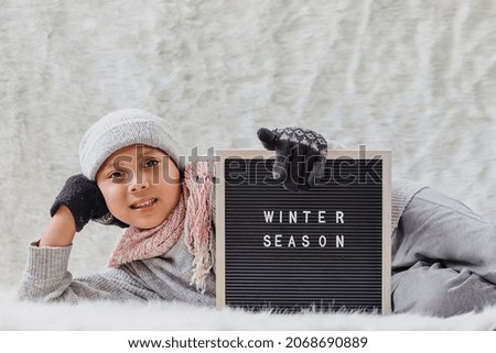 A boy wearing winter clothes welcomes winter season happily