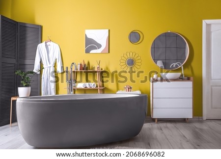 Trendy interior of bathroom with yellow wall