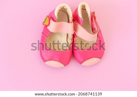Pink Baby girl shoes, babies shoes on pink background with copy space, flat lay