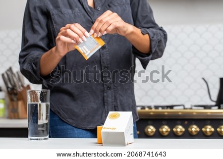 Opening pack of nootropics supplements in kitchen Royalty-Free Stock Photo #2068741643