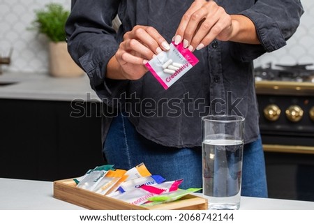 Opening pack of pills in kitchen