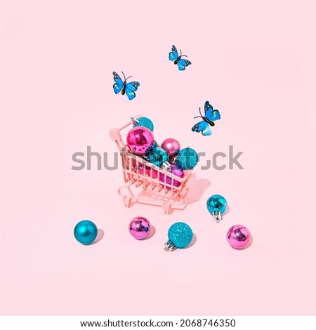 Christmas decoration in a pink stroller with blue butterflies. Minimal trendy idea for the Holidays.