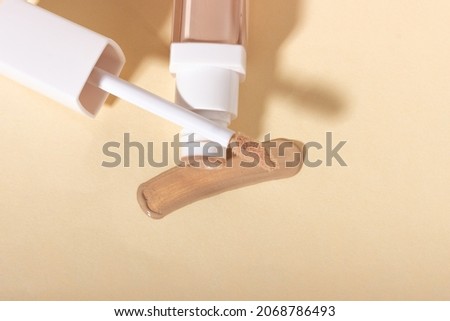 Concealer cream on a background with shadows. Face corrector on beige background with copy space. Blank mockup for product Royalty-Free Stock Photo #2068786493