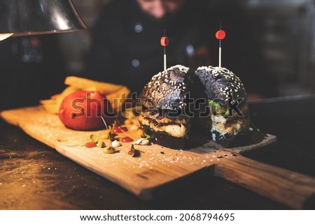 Cuttlefish and squid burger on a wood plate.