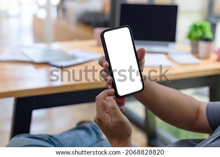 Close up view of man holding smartphone blank white screen for text message or information.