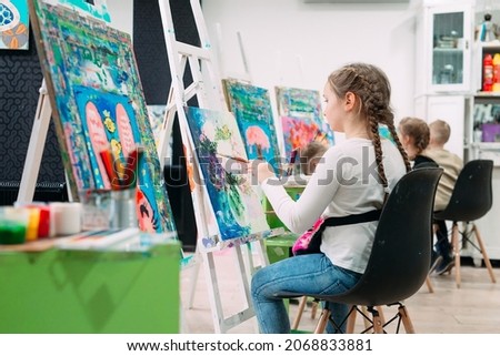 Workshop of the artist. Little girl artist paints a picture