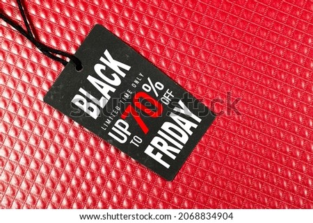 black Friday sale concept on black tag with red leather square background