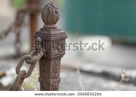 The old rusty metal chain barrier