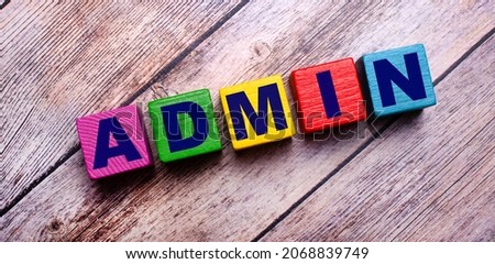 On a dark wooden background, multicolored bright wooden cubes with the text ADMIN