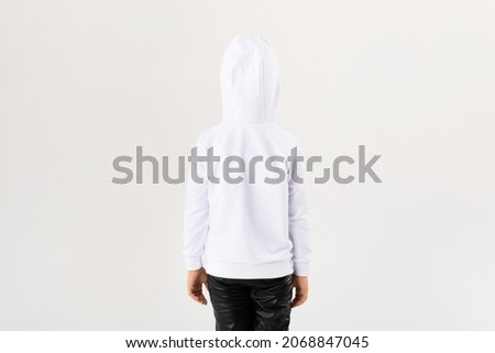 Child in white hoodie with hood. Back view.