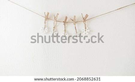 white snowflakes suspended on a clothespin 2022