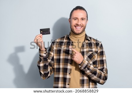 Photo of young guy hold bank card indicate finger debit card advertise advise income isolated over grey color background